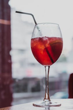 Dikey şarap kadehi alkollü, siyah plastik pipetli kokteyl içeceği. Damlalar yoğunlaşır. Kapat.