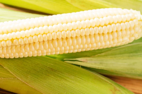 En söt gul råmjölk majs kolvar majs med vitt granulat grön färsk ingrediens produkt. Trä bakgrund tabell — Stockfoto