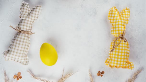 Stop motion Easter video of yellow and beige handmade bunnies pushing yellow Easter egg to each other playing football — Stock Video