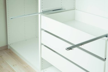 Çekmece korkuluğu dolaba yerleştirilmiş, kendi kendine tıkırdayan vidalarla sabitlenmiş. Beyaz elbise ya da gardırop monte ediliyor. Mobilyaların kendi kendine montajı, DIY, mobilya onarımı ve yeniden düzenleme