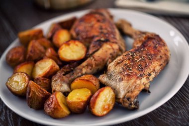 Tabakta kızarmış tavuk budu ve patates..