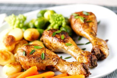 Kızarmış tavuk budu, patates, havuç, brokoli ve Brüksel lahanası.