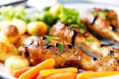 Kızarmış tavuk budu, patates, havuç, brokoli ve Brüksel lahanası.