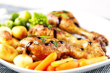 Kızarmış tavuk budu, patates, havuç, brokoli ve Brüksel lahanası.