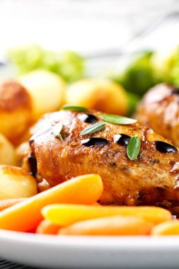 Kızarmış tavuk budu, patates, havuç, brokoli ve Brüksel lahanası.