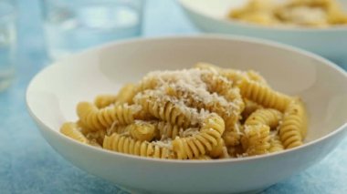 Genovese soslu makarna yiyen bir adam taze fesleğenli, zeytinyağlı, sarımsaklı ve çam fıstıklı..