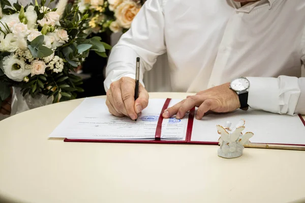 Damat belgeyi imzalar.