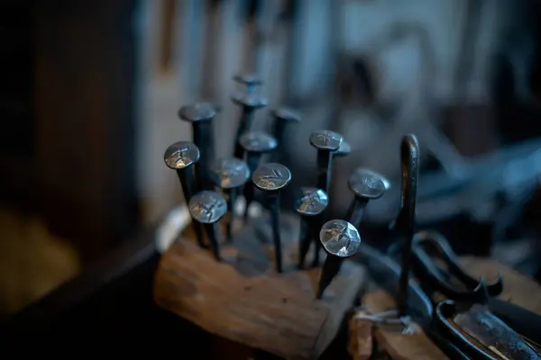 Blacksmith decorative elements horseshoes nails at forge, workshop. Handmade, craftsmanship and blacksmithing concept