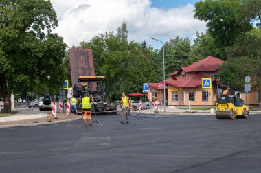 4 Ağustos 2021: İnşaat alanı Sigulda, Letonya 'da yeni asfalt yol kaldırımı, yol yapım işçileri ve yol yapım makineleri sahnesi inşa ediyor