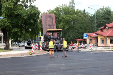 4 Ağustos 2021: İnşaat alanı Sigulda, Letonya 'da yeni asfalt yol kaldırımı, yol yapım işçileri ve yol yapım makineleri sahnesi inşa ediyor