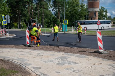4 Ağustos 2021: İnşaat alanı Sigulda, Letonya 'da yeni asfalt yol kaldırımı, yol yapım işçileri ve yol yapım makineleri sahnesi inşa ediyor
