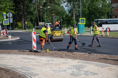 4 Ağustos 2021: İnşaat alanı Sigulda, Letonya 'da yeni asfalt yol kaldırımı, yol yapım işçileri ve yol yapım makineleri sahnesi inşa ediyor