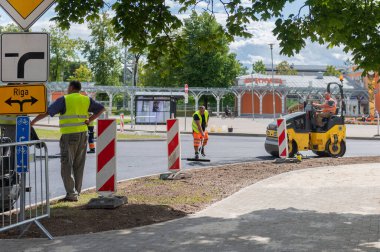 4 Ağustos 2021: İnşaat alanı Sigulda, Letonya 'da yeni asfalt yol kaldırımı, yol yapım işçileri ve yol yapım makineleri sahnesi inşa ediyor