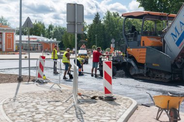 4 Ağustos 2021: İnşaat alanı Sigulda, Letonya 'da yeni asfalt yol kaldırımı, yol yapım işçileri ve yol yapım makineleri sahnesi inşa ediyor