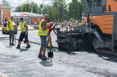4 Ağustos 2021: İnşaat alanı Sigulda, Letonya 'da yeni asfalt yol kaldırımı, yol yapım işçileri ve yol yapım makineleri sahnesi inşa ediyor