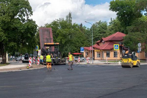 4 Ağustos 2021: İnşaat alanı Sigulda, Letonya 'da yeni asfalt yol kaldırımı, yol yapım işçileri ve yol yapım makineleri sahnesi inşa ediyor