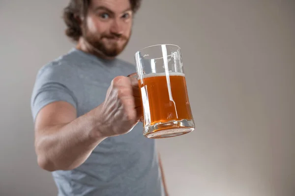 Büyük Bira Bardağını Gri Arka Planda Tutan Sakallı Adam — Stok fotoğraf