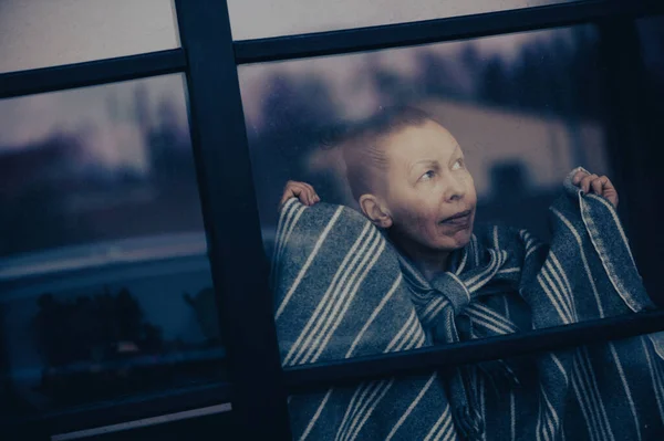Thoughtful Middle Aged Woman Looks Dirty Window Glass — стоковое фото