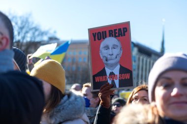 Riga, Letonya - 05 Mart 2022: Ukrayna 'daki savaşı ve Rusya' nın işgalini protesto. Ukrayna 'yı destekleyen ve Putin' in savaşı durdurmasını isteyen gösterilerde bayrakları, işaretleri ve posterleri olan bir kalabalık..
