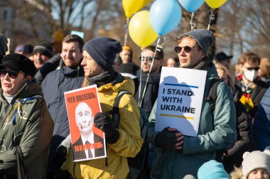 Riga, Letonya - 05 Mart 2022: Ukrayna 'daki savaşı ve Rusya' nın işgalini protesto. Ukrayna 'yı destekleyen ve Putin' in savaşı durdurmasını isteyen gösterilerde bayrakları, işaretleri ve posterleri olan bir kalabalık..