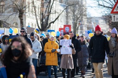 Riga, Letonya - 05 Mart 2022: Ukrayna 'daki savaşı ve Rusya' nın işgalini protesto. Ukrayna 'yı destekleyen ve Putin' in savaşı durdurmasını isteyen gösterilerde bayrakları, işaretleri ve posterleri olan bir kalabalık..