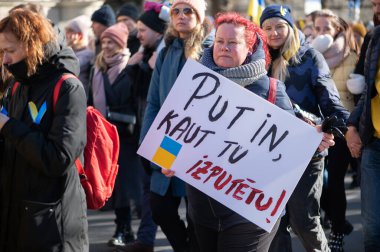 Riga, Letonya - 05 Mart 2022: Ukrayna 'daki savaşı ve Rusya' nın işgalini protesto. Ukrayna 'yı destekleyen ve Putin' in savaşı durdurmasını isteyen gösterilerde bayrakları, işaretleri ve posterleri olan bir kalabalık..