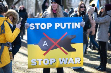 Riga, Letonya - 05 Mart 2022: Ukrayna 'daki savaşı ve Rusya' nın işgalini protesto. Ukrayna 'yı destekleyen ve Putin' in savaşı durdurmasını isteyen gösterilerde bayrakları, işaretleri ve posterleri olan bir kalabalık..