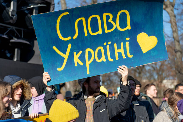Riga, Latvia - March 05, 2022: Protest against war in Ukraine and Russia's invasion. Crowd of people with flags, signs and posters at demonstration in support of Ukraine to demand Putin to stop war.