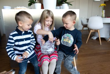 Annem tatil pastası hazırlarken mutfakta üç çocuk krema yiyor.