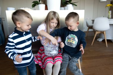 Annem tatil pastası hazırlarken mutfakta üç çocuk krema yiyor.