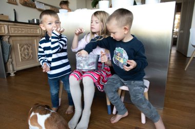 Annem tatil pastası hazırlarken mutfakta üç çocuk krema yiyor.