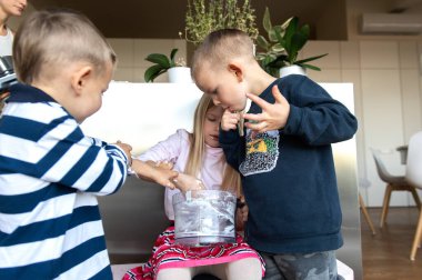 Annem tatil pastası hazırlarken mutfakta üç çocuk krema yiyor.