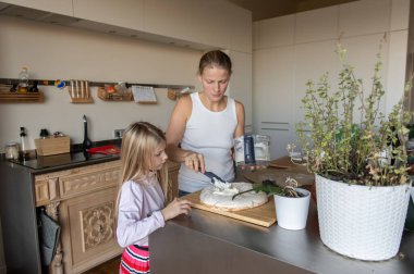 Anne ve kızı evde tatlı tatlı kremalı pasta hazırlıyorlar.