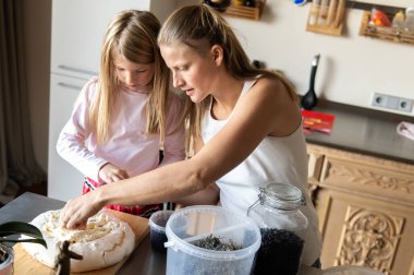 Anne ve kızı evde tatlı tatlı kremalı pasta hazırlıyorlar.