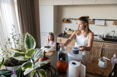 Anne ve kızı evde tatlı tatlı kremalı pasta hazırlıyorlar.