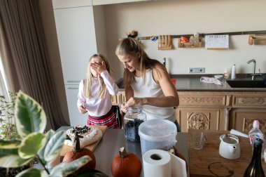 Anne ve kızı evde tatlı tatlı kremalı pasta hazırlıyorlar.