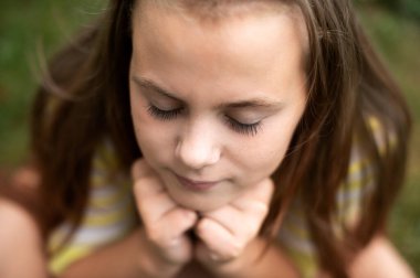 view from above on the girl's face, which pressed her head to her hands and closed her eyes