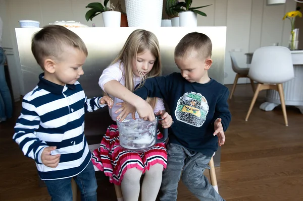 Annem tatil pastası hazırlarken mutfakta üç çocuk krema yiyor.