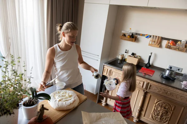 Anne ve kızı evde tatlı tatlı kremalı pasta hazırlıyorlar.