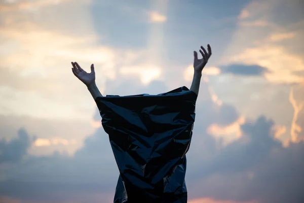 Desperate Woman Hands Out Black Plastic Bag Sunset Sky Background — Stock fotografie