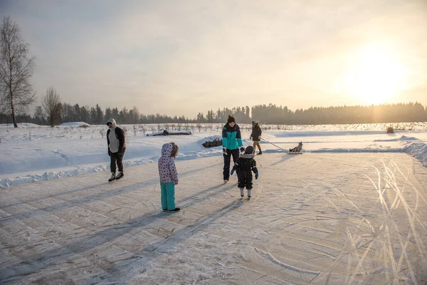 Üç çocuklu mutlu bir aile buz pateni pistinde eğleniyor.