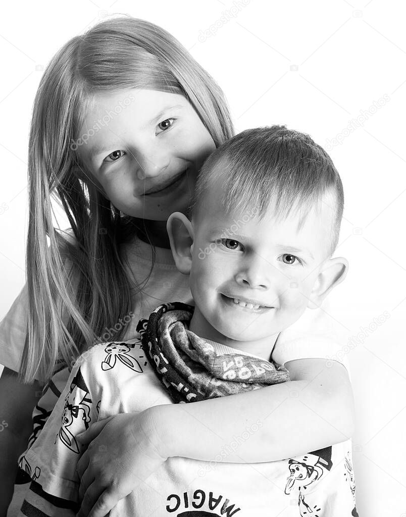 Two happy little children - sister and brother smile and hug,black and white