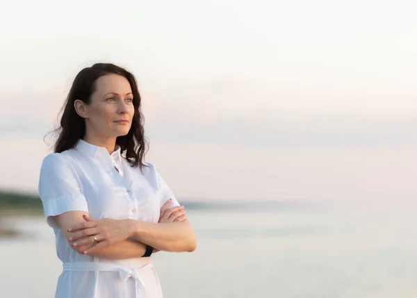 Portrait of a mature woman by the sea at sunset