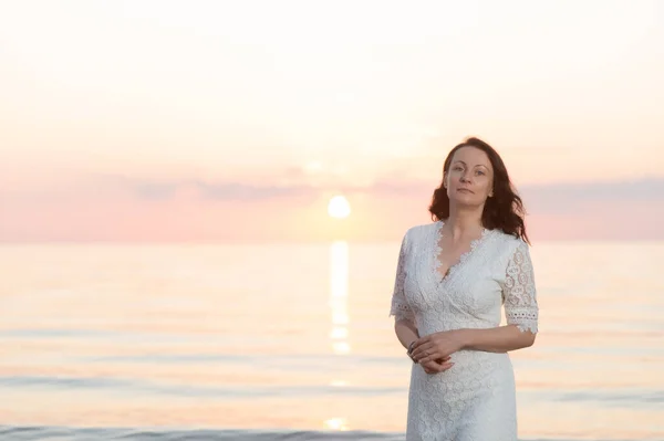 Portrait of a mature woman by the sea at sunset