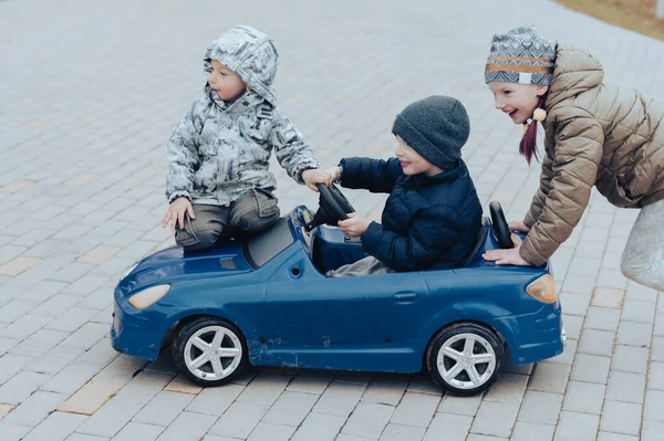 Due Bambini Felici Che Divertono Guidano Una Macchina Giocattolo Blu — Foto Stock