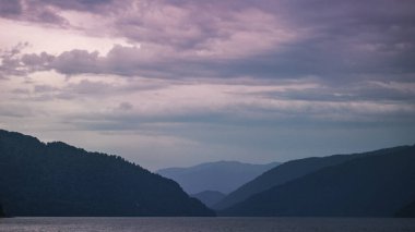 Mor gökyüzüne karşı dağların siluetleri. Teletskoye Gölü, Rusya, Altai.