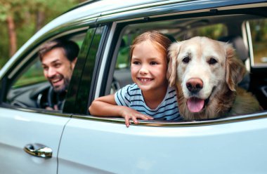 Arkadaşı köpek Labrador 'la küçük şirin bir kız çocuğu ve ailesi hafta sonunu neşeyle pencereden dışarı bakarak geçiriyorlar. Boş zaman, seyahat, turizm..