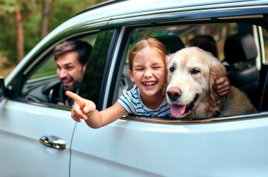 Arkadaşı köpek Labrador 'la küçük şirin bir kız çocuğu ve ailesi hafta sonunu neşeyle pencereden dışarı bakarak geçiriyorlar. Boş zaman, seyahat, turizm..