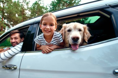 Arkadaşı köpek Labrador 'la küçük şirin bir kız çocuğu ve ailesi hafta sonunu neşeyle pencereden dışarı bakarak geçiriyorlar. Boş zaman, seyahat, turizm..