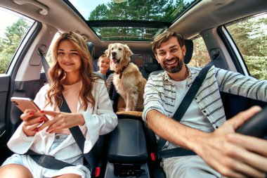Bütün aile hafta sonu için araba sürüyor. Annemle babam kızlarıyla ve Labrador köpeğiyle arabada oturuyorlar. Boş zaman, seyahat, turizm..